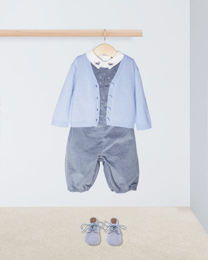 Baby outfit with light blue cardigan,  corduroy romper, and shoes on a white background