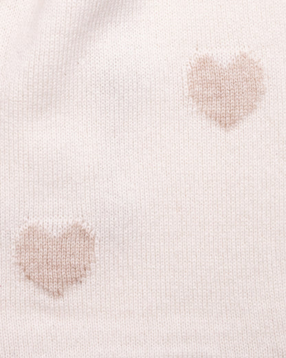 Close-up of a light cream cashmere scarf with gold-hue heart patterns