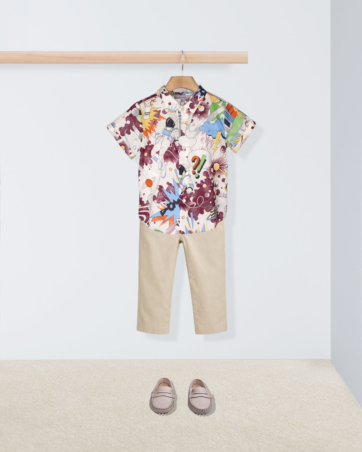 Children's outfit with a colorful shirt and beige pants on a white background