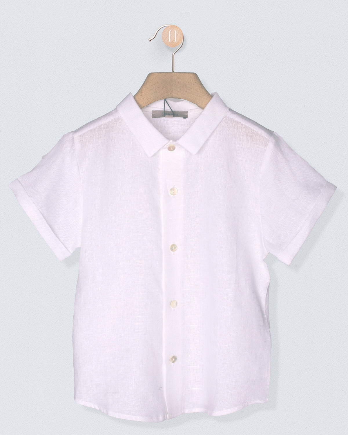 white short-sleeve shirt on a hanger against a light gray background