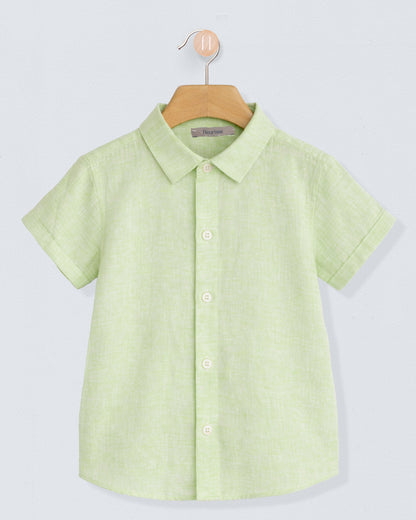 Green shirt on a hanger against a light gray background