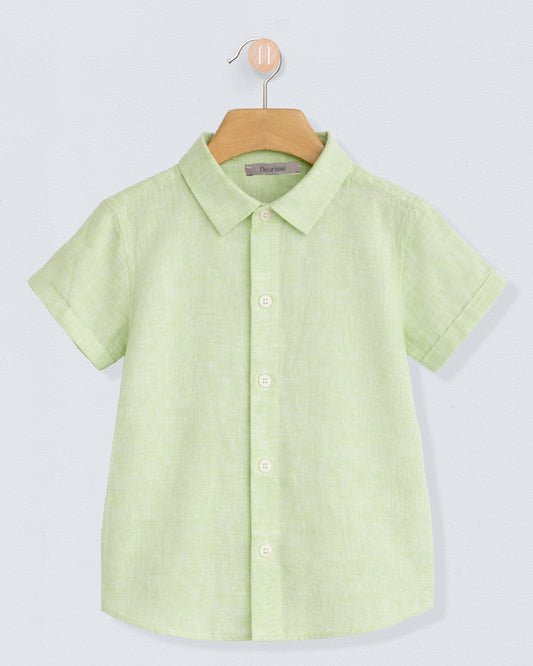 Green shirt on a hanger against a light gray background