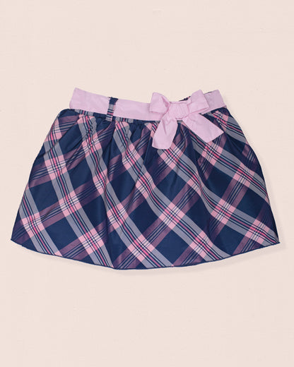 Navy and pink plaid skirt with a bow on a beige background