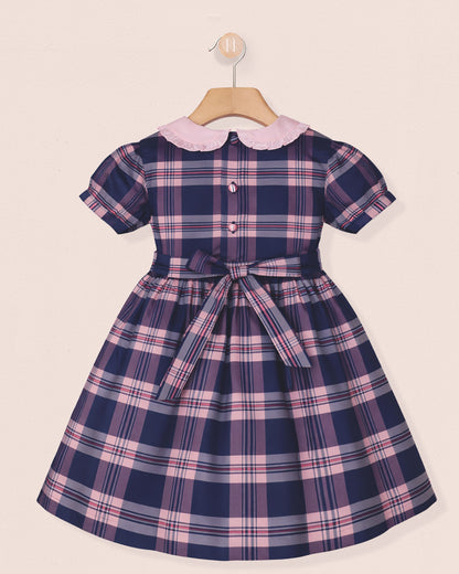 Navy and pink plaid dress with a white collar on a beige background