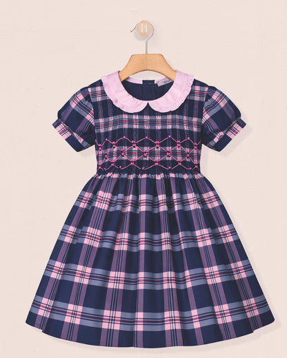 Navy and pink plaid dress with a white collar on a beige background