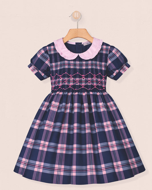Navy and pink plaid dress with a white collar on a beige background