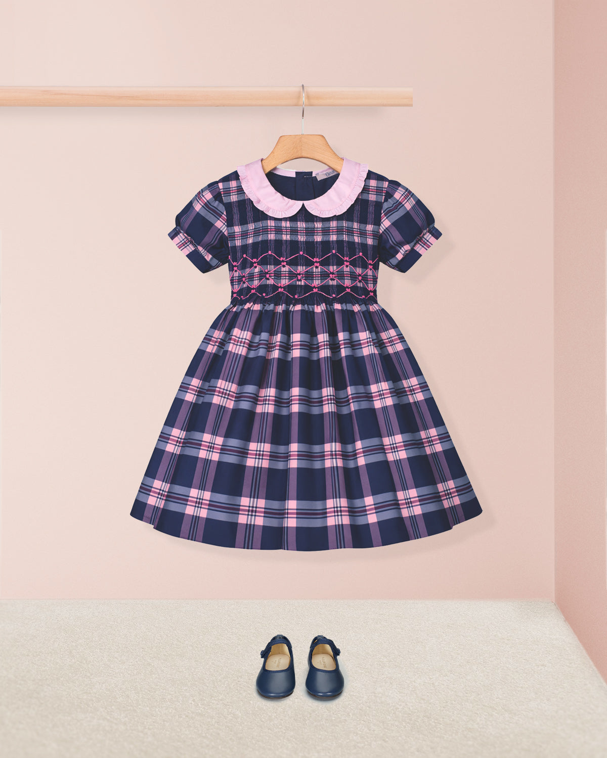 Plaid dress with pink collar and matching shoes on a light pink background