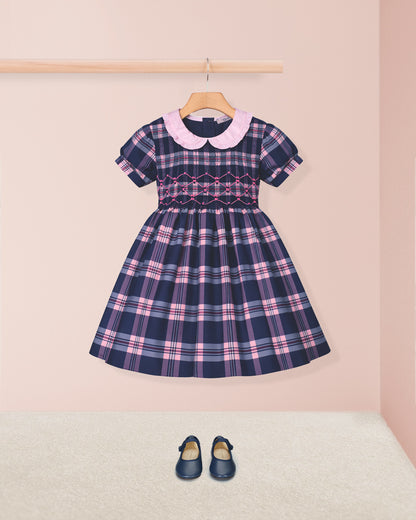 Plaid dress with pink collar and matching shoes on a light pink background