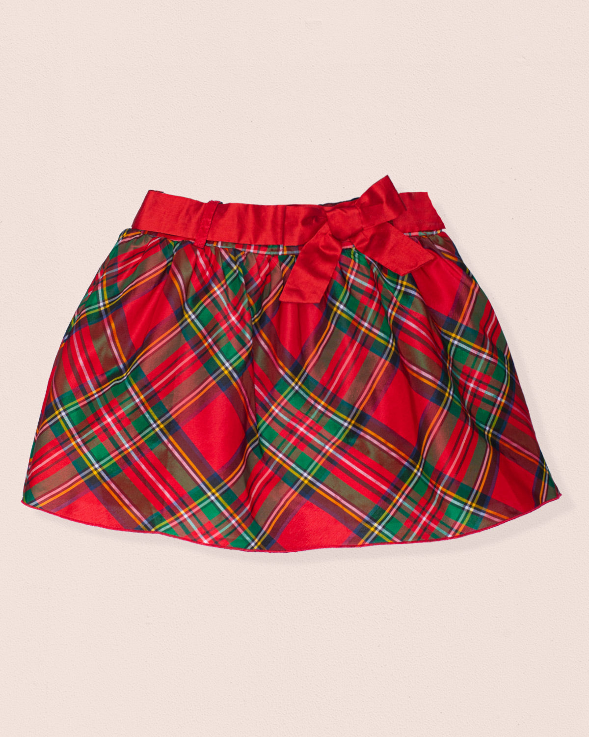 Red plaid skirt with a bow on a beige background