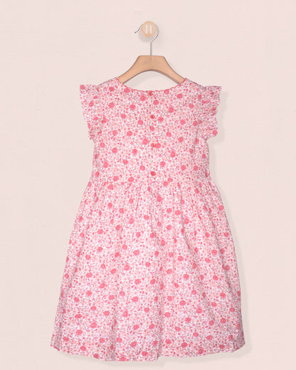 Pink floral dress on a hanger against a light pink background