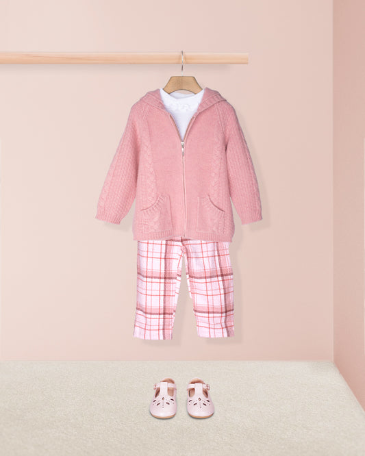 Pink children's outfit with plaid pants and shoes on a pink background