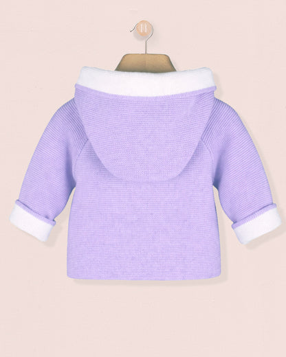Purple baby sweater with white trim on a beige background