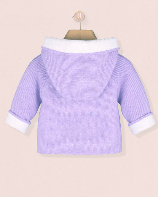 Purple baby sweater with white trim on a beige background