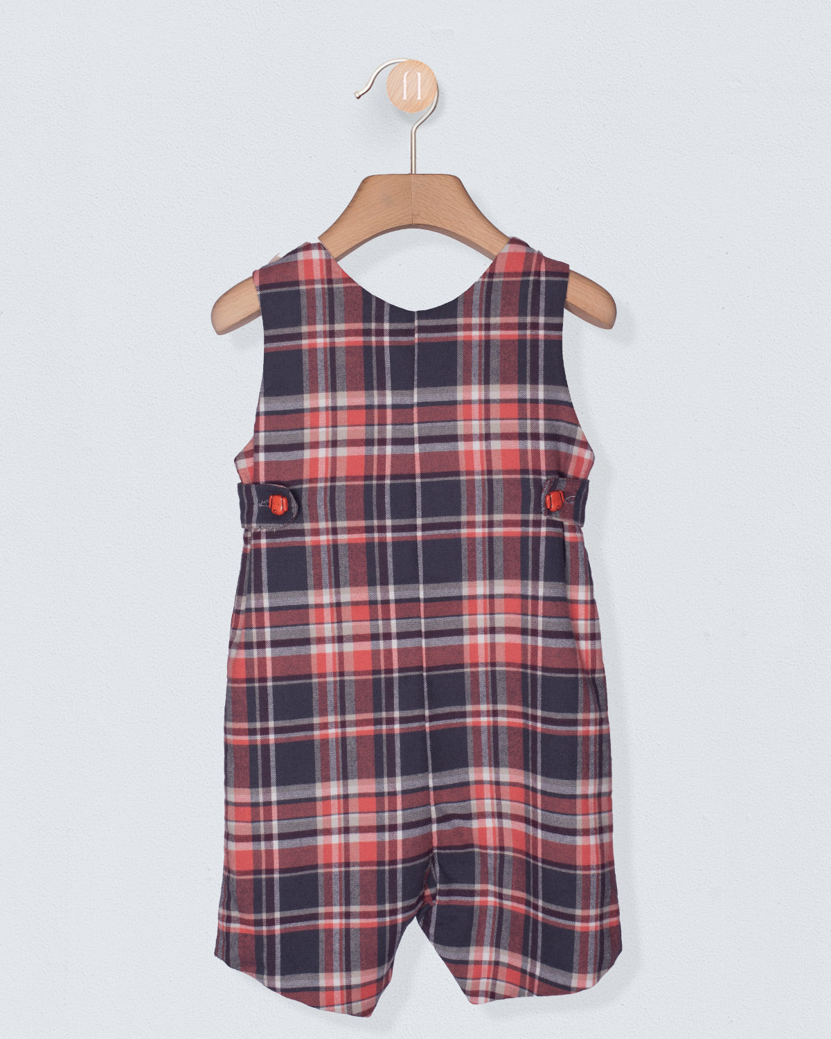 Plaid dress on a hanger against a light gray background