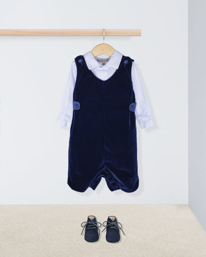 Navy blue velvet pinafore with white shirt and shoes on a light background