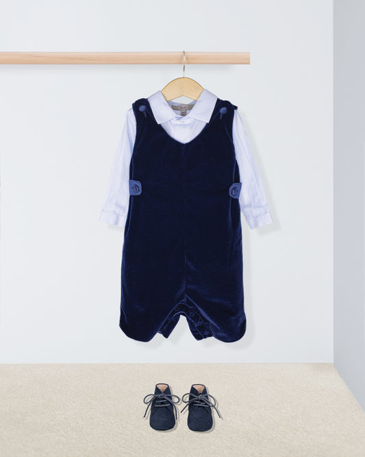 Navy blue velvet pinafore with white shirt and shoes on a light background