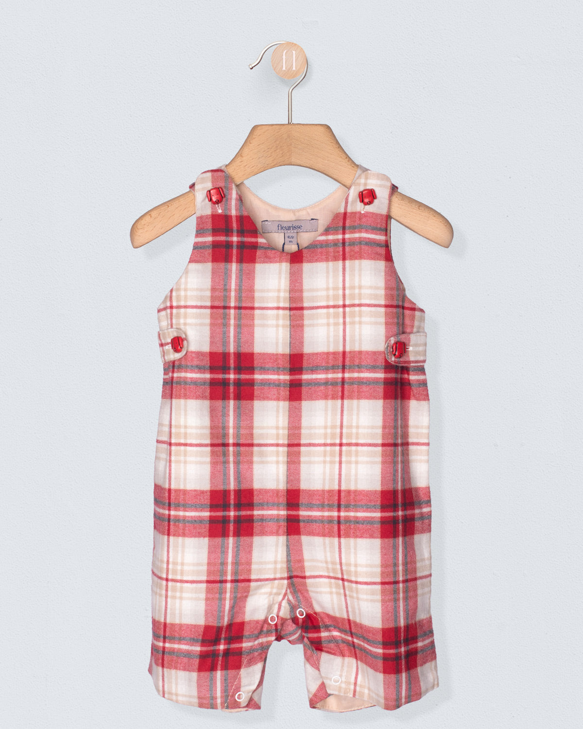 Red and white plaid baby romper on a hanger against a light gray background