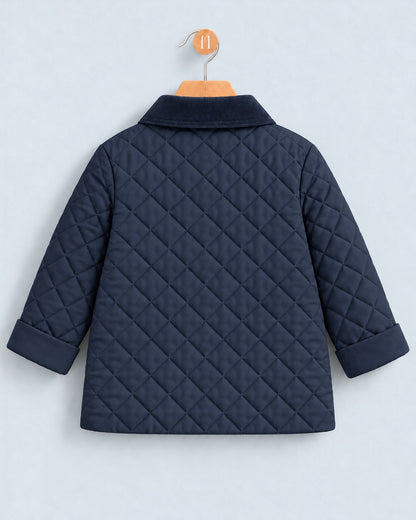 A navy blue quilted jacket with a collar and long sleeves, shown from the back on a wooden hanger against a light gray background.