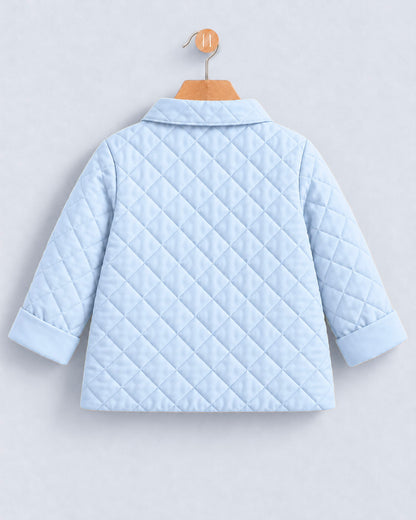 A light blue quilted jacket with a collar and three-quarter sleeves, shown from the back on a wooden hanger against a light gray background.