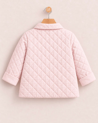 A light pink quilted jacket with long sleeves and a collar, shown from the back on a wooden hanger against a light beige background.