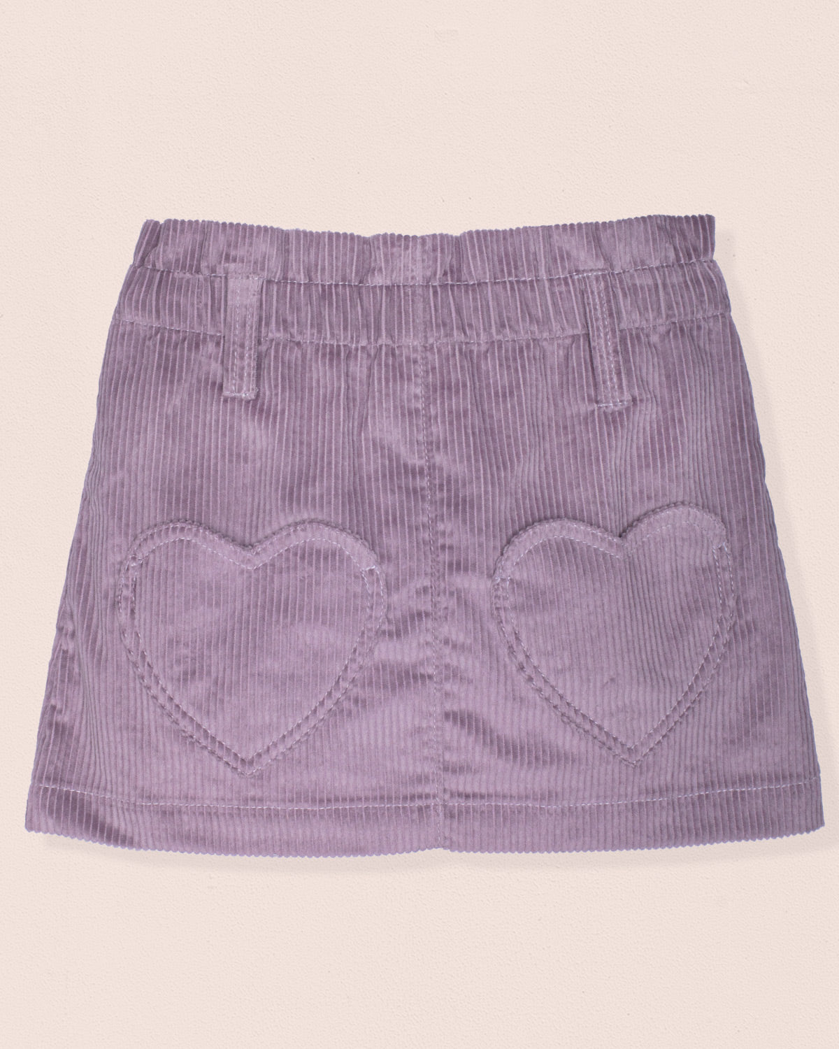 Purple corduroy skirt with heart shapes on a beige background