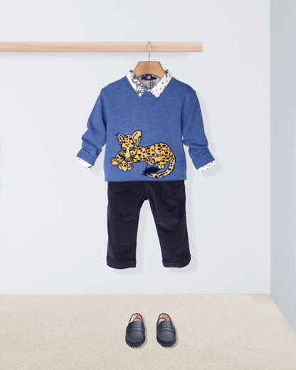 Children's outfit with blue sweater and black pants on a hanger against a white background