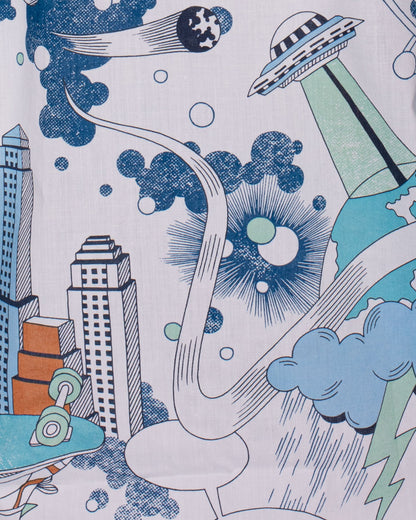 Close-up detail of the Bernard Liberty Blue Robots Shirt fabric showing a city skyline, UFO, clouds, and lightning bolt in blue and green tones. The design is cartoon-style, emphasizing the vibrant and imaginative Liberty print.
