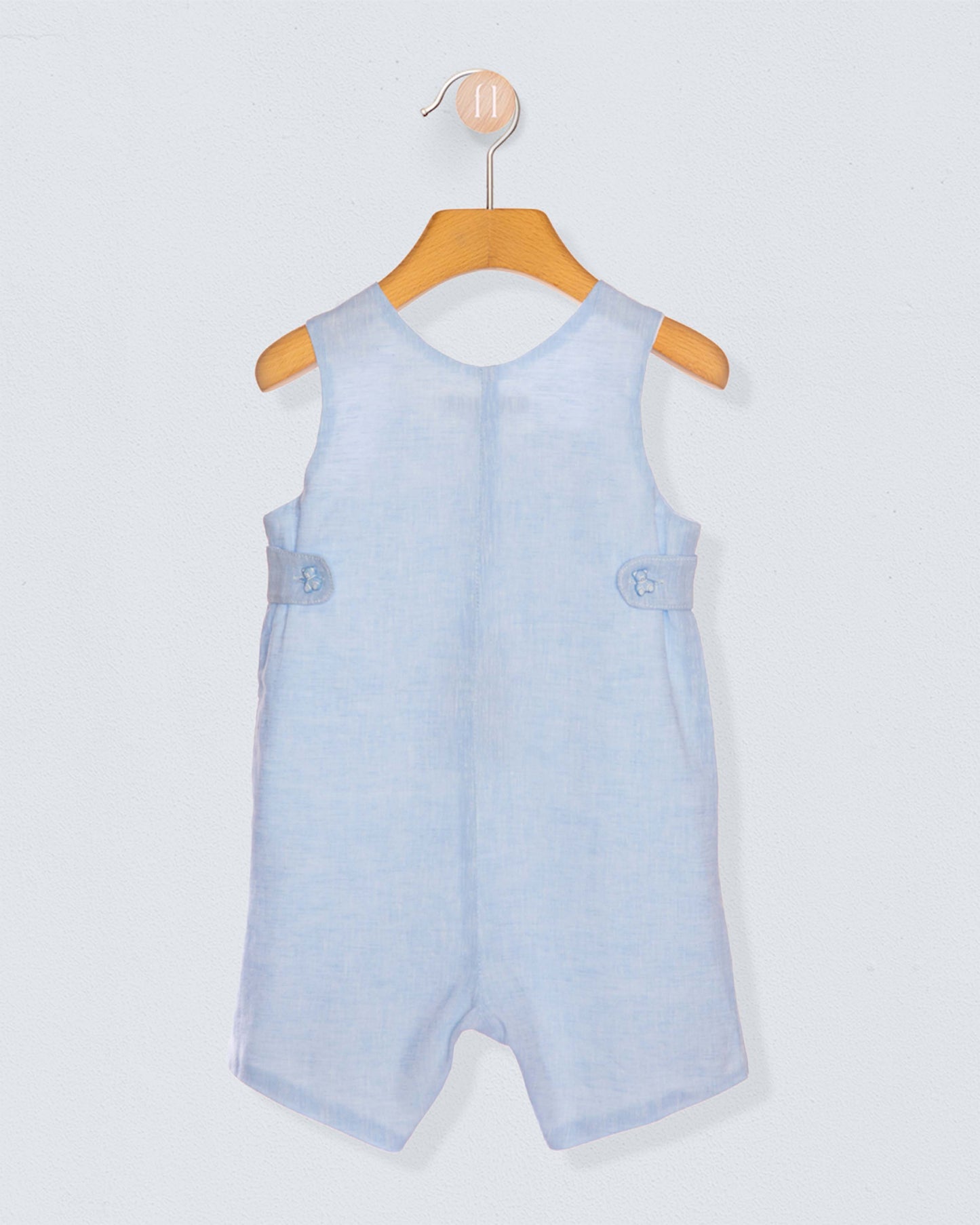 Back of light blue baby romper on a wooden hanger against a light gray background