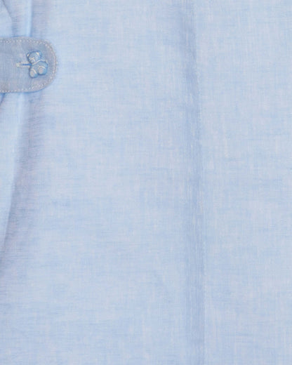 Close-up of a light blue shortall with a teddy bear button detail.
