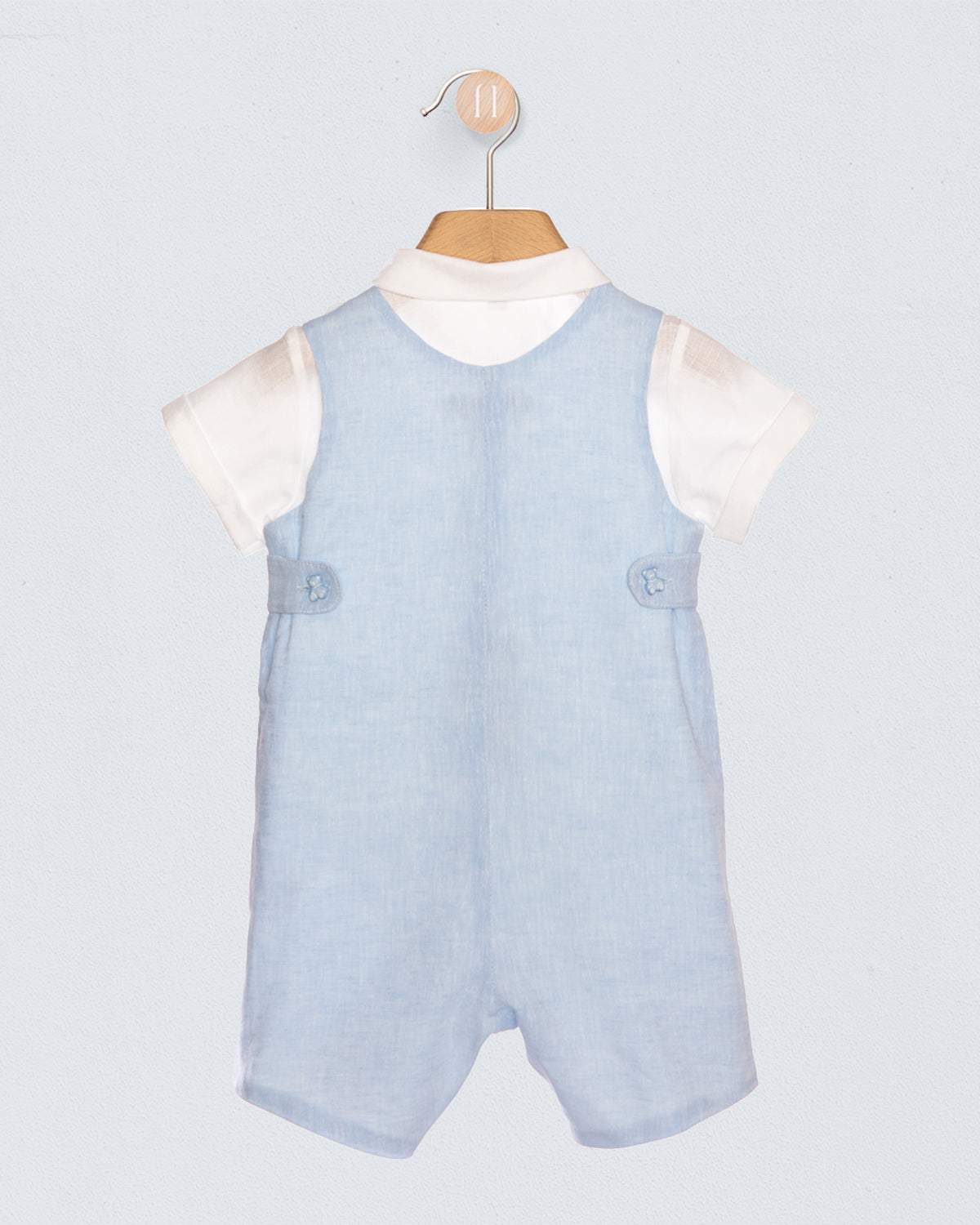 Light blue romper with white sleeves on a hanger against a light gray background