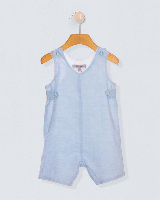 Light blue denim romper on a wooden hanger against a light gray background