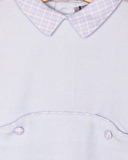 Detail close-up of the checkered Peter Pan collar and waist piping on the light blue velour footie, showing fabric texture and stitching.
