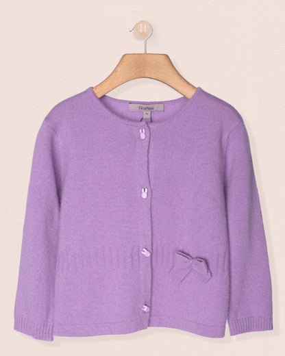 Purple cardigan on a wooden hanger against a beige background