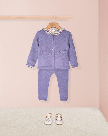 Purple baby outfit with matching shoes on a pink background