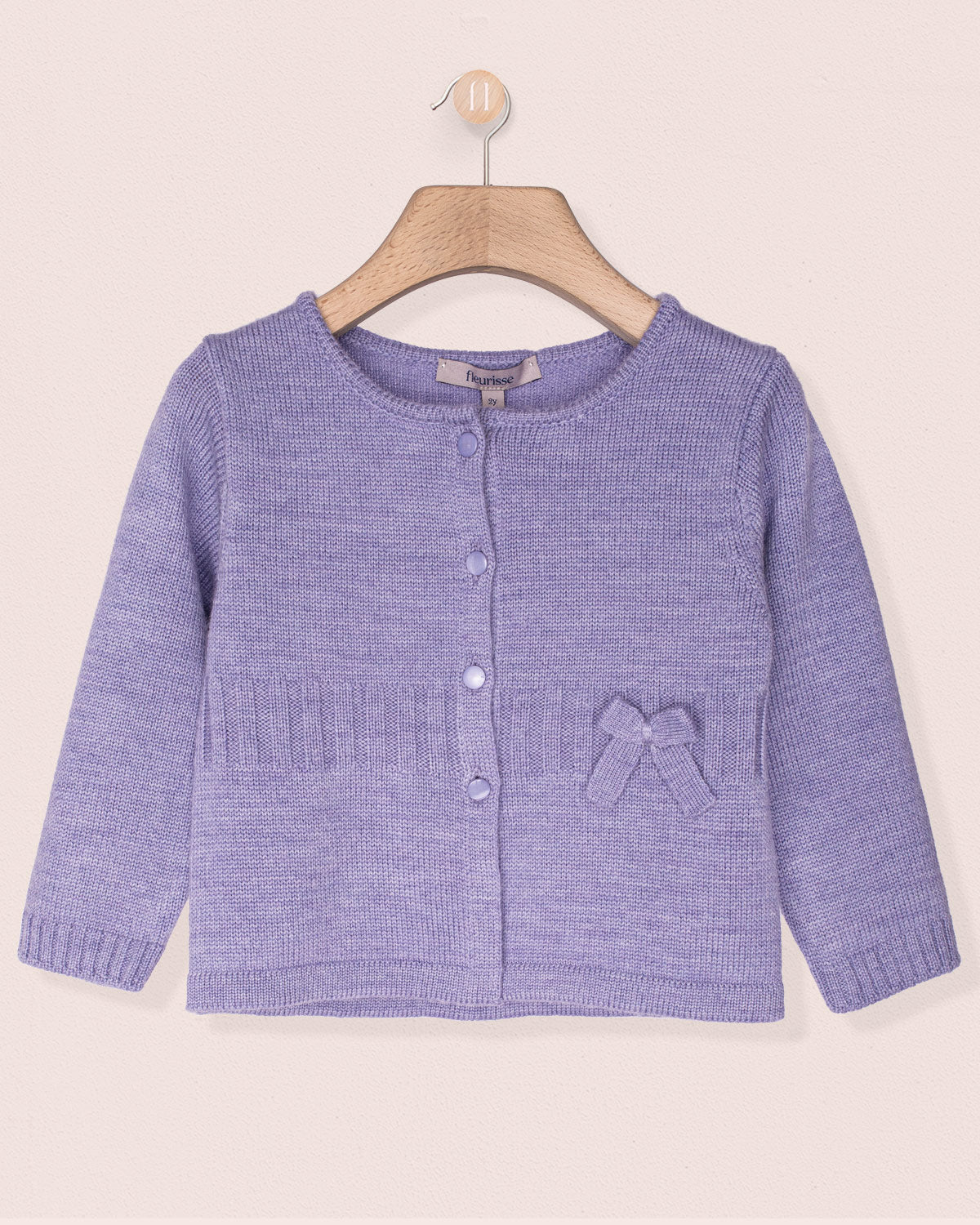 Purple knitted cardigan with a bow on a beige background