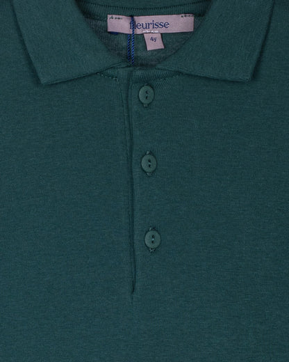 Close-up of the hunter green polo shirt showcasing the brushed cotton texture, soft point collar, and three high-quality corozo buttons on the placket.