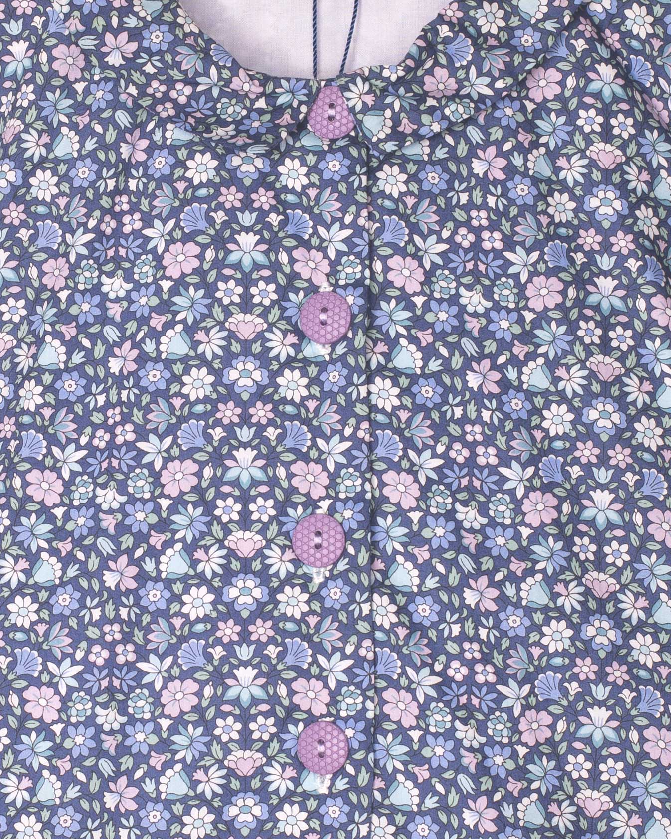 Floral patterned fabric with small flowers in pink, blue, and white on a dark blue background.
