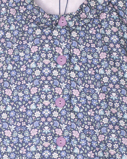 Floral patterned fabric with small flowers in pink, blue, and white on a dark blue background.