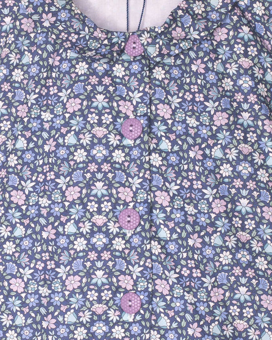 Floral patterned fabric with small flowers in pink, blue, and white on a dark blue background.