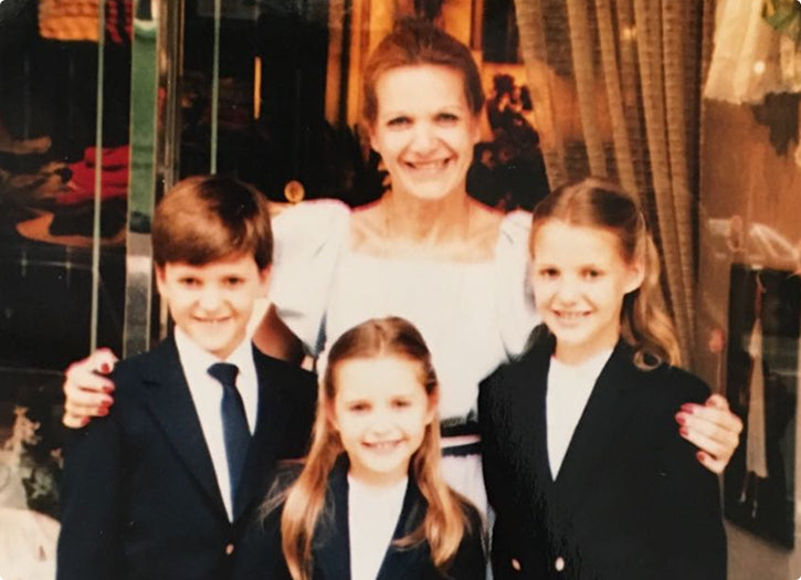 Woman with three children in formal attire in a decorated room