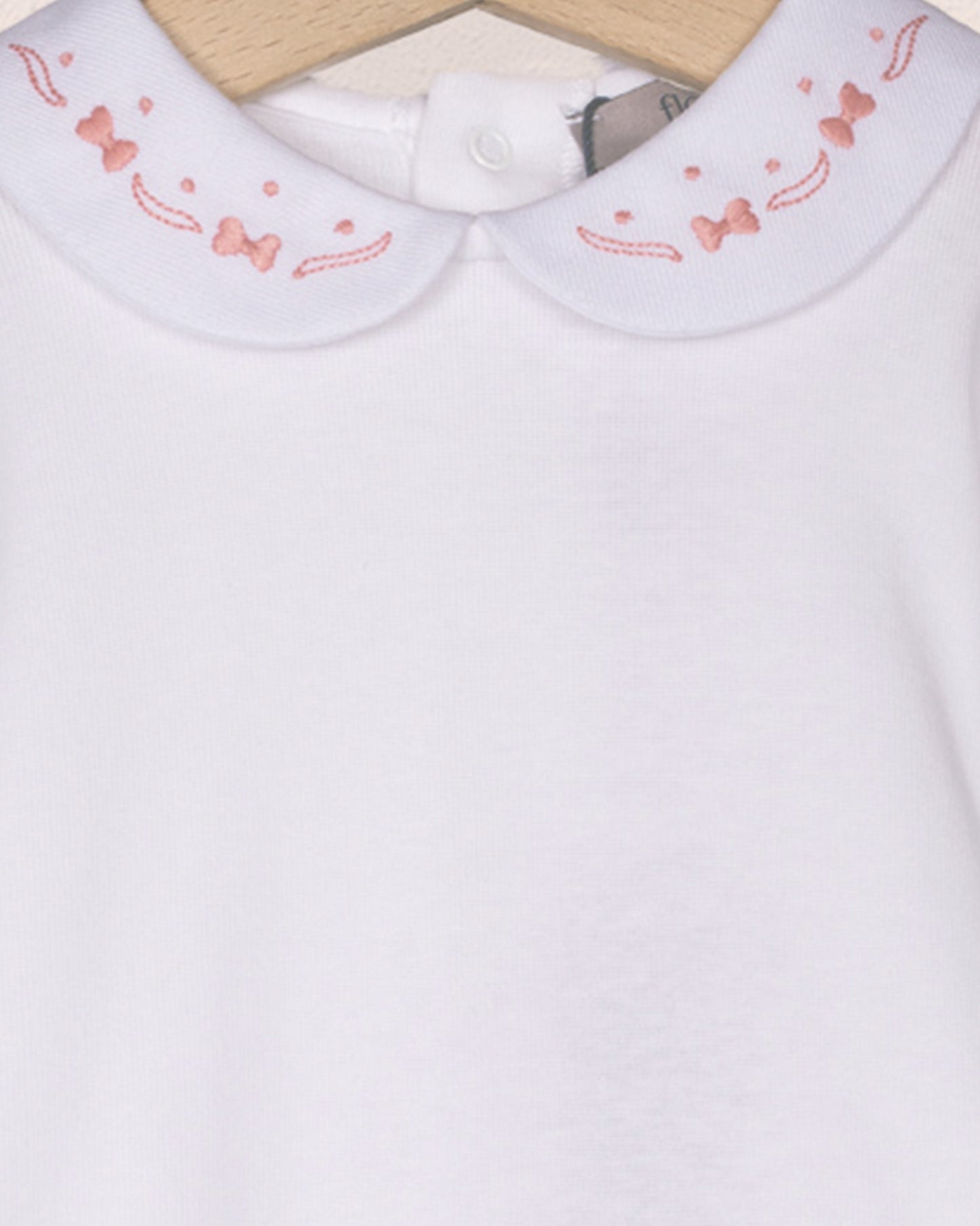White shirt with a embroidered pink collar on a white background