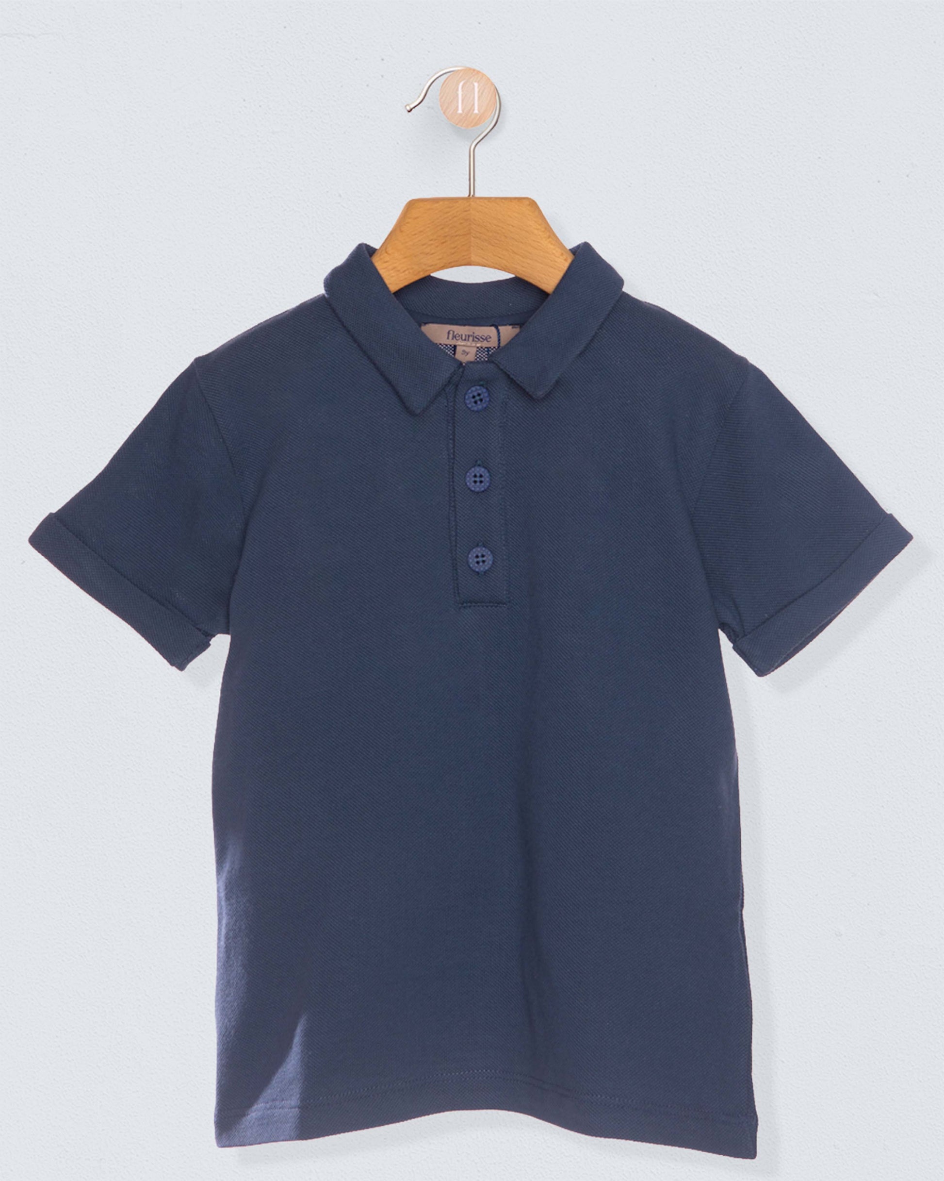 navy polo shirt on hanger against light blue grey background