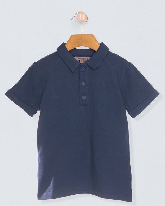 navy polo shirt on hanger against light blue grey background