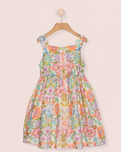 Floral dress on a hanger against a light pink background