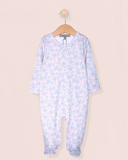Floral-patterned baby onesie on a hanger against a beige background