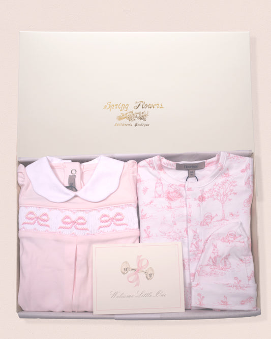 Baby outfit set with pink floral design and smocked bows in a gift box with card