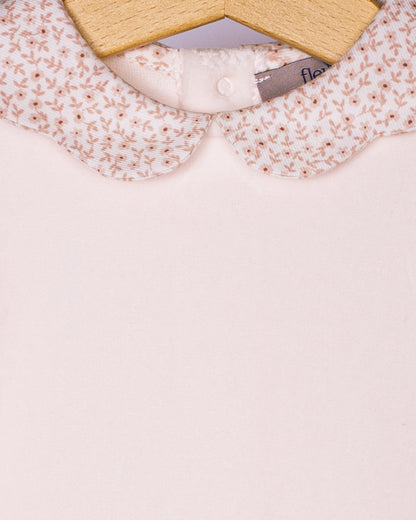 Close-up view of the pink floral scallop edge collar on the baby girl’s footie romper, highlighting the delicate floral print and the smooth texture of the soft Italian velour fabric.