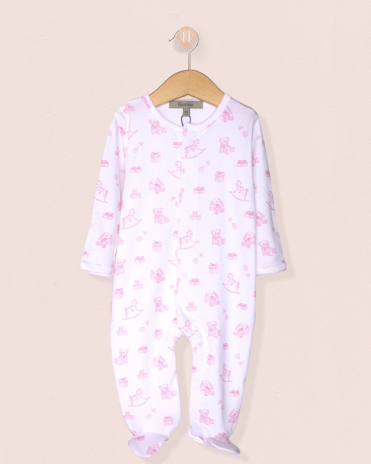 Baby onesie with pink floral pattern on a beige background