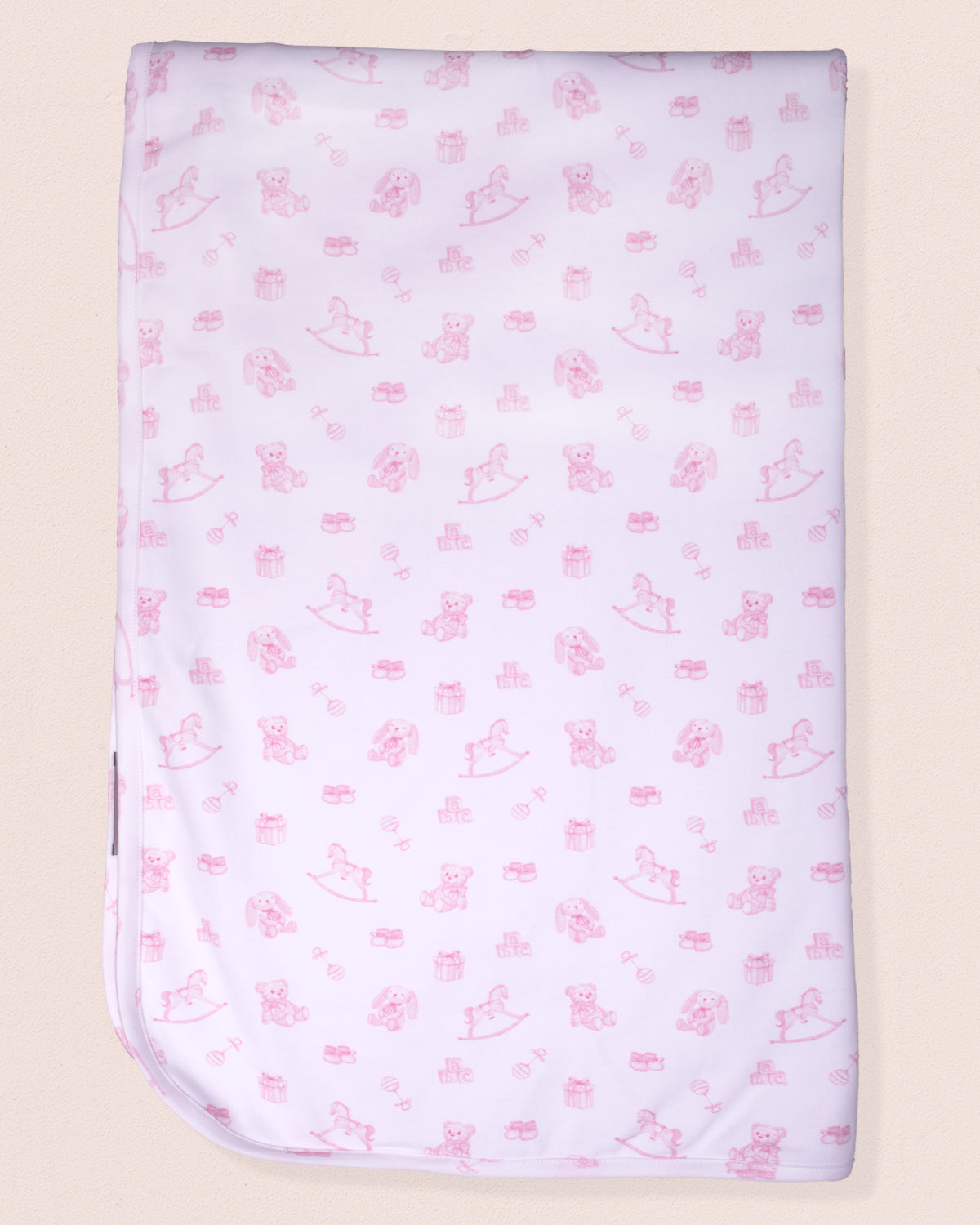 Baby blanket with pink animal pattern on a beige background