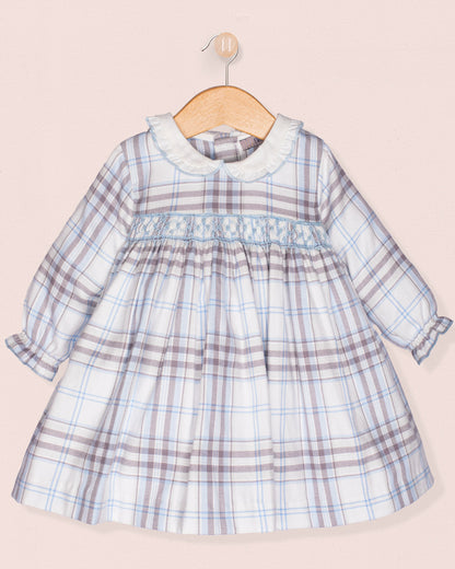 Plaid dress on a wooden hanger against a light pink background